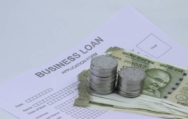 business loan application form and indian notes and coins.